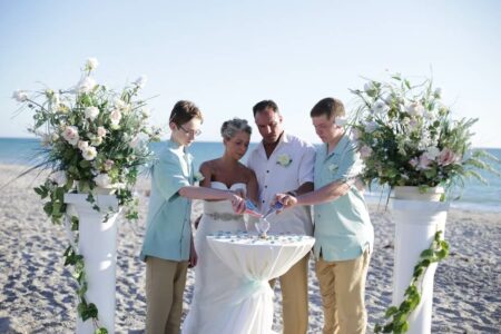 white columns with white chairs and white sashes | beach wedding in florida