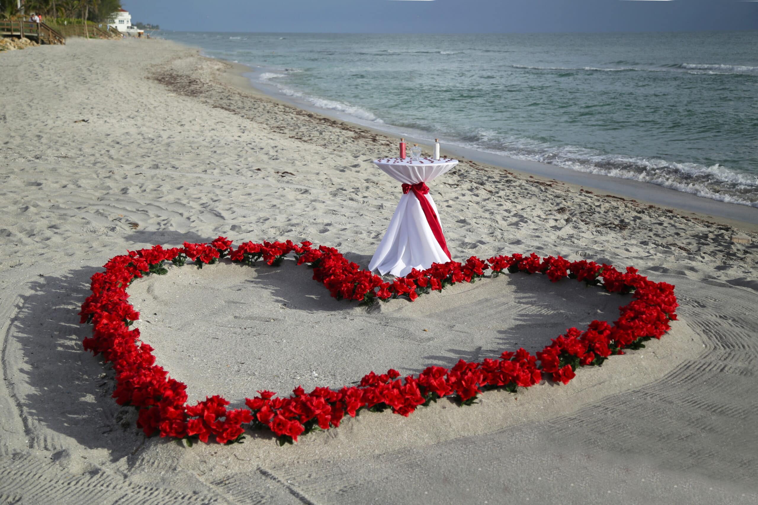 Beach Wedding Ceremony Table with Heart of Red Roses in the sand