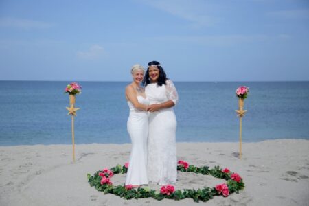 LGBTQ+ Beach Wedding Elopement Ceremony | Circle of Florals in Sand Around Couple