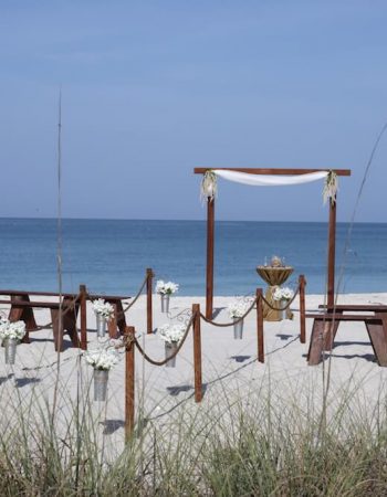 Handmade wooden boho beach wedding ceremony design with bench seating and roped aisle